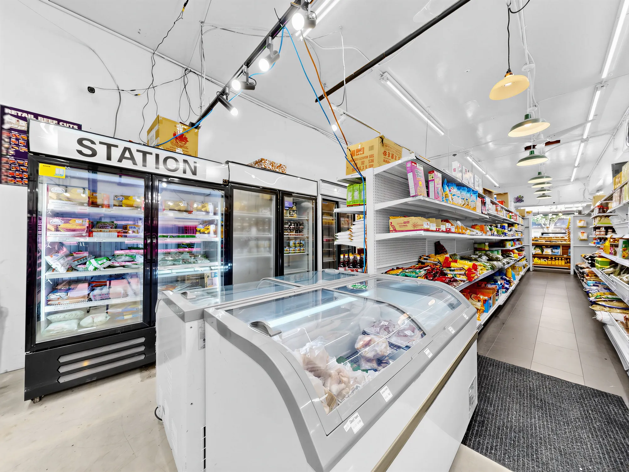 Glass-front deli and meat display cases under the station sign